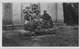 Family posing for photograph outside of house