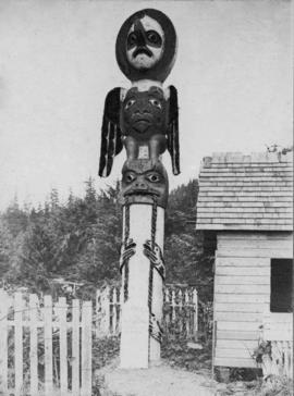 Totem pole at end of small building