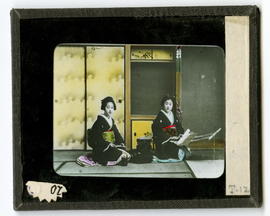 Two women kneeling in front of screens