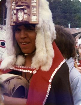 Participant in button blanket, headdress, and with drum