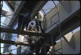 Workers lift a totem pole into position