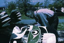 Mungo Martin painting a totem pole