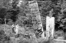 Two men recovering a house post from SG̱ang Gwaay (Anthony Island)