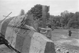 [Norman continues shaping hull]