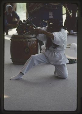 Masked performer holding stick