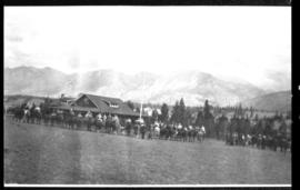 View of individuals on horseback in front of large building