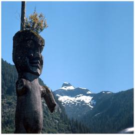 Gwayasdums (Gilford Island): mountain with totem pole in foreground