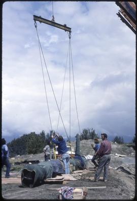 A totem pole being lowered onto the ground