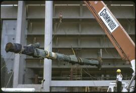 A totem pole being lifted by a crane