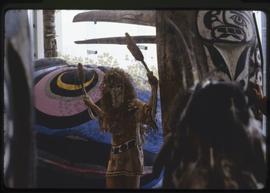 A masked performer in a piece by Evelyn Roth