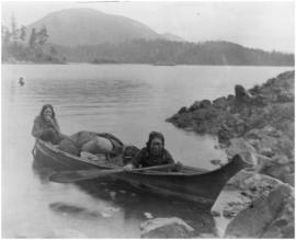 Two women in canoe carrying goods