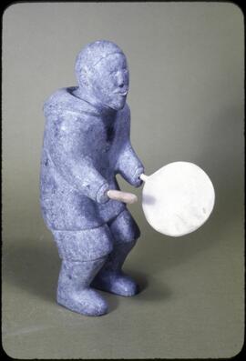 A sculpture of an Inuit man playing the drum