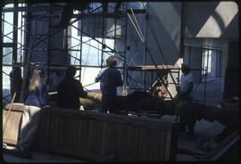 Workers prepare to raise a totem pole in the Museum of Anthropology