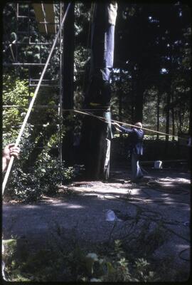 A totem pole being lowered from its position in Totem Park