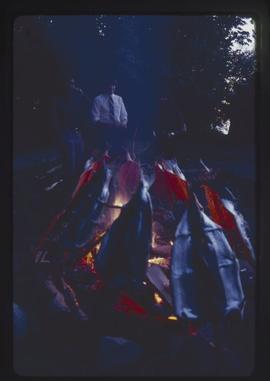 Closeup of salmon on the fire with people in background