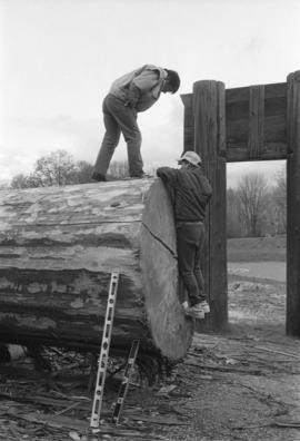 [Norman and Isaac marking canoe log]