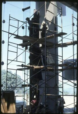 Workers securing a totem pole in the Museum of Anthropology