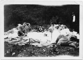 Eight picnickers reclining outdoors