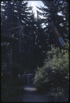 A crane preparing to lift a totem pole
