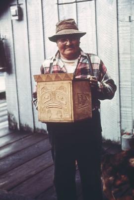 Unidentified man holding carved wooden box